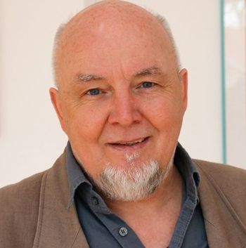 Foto Jürgen Baumgartner. Halbglatze, kurze weiße Haare, Bart am Kinn.
